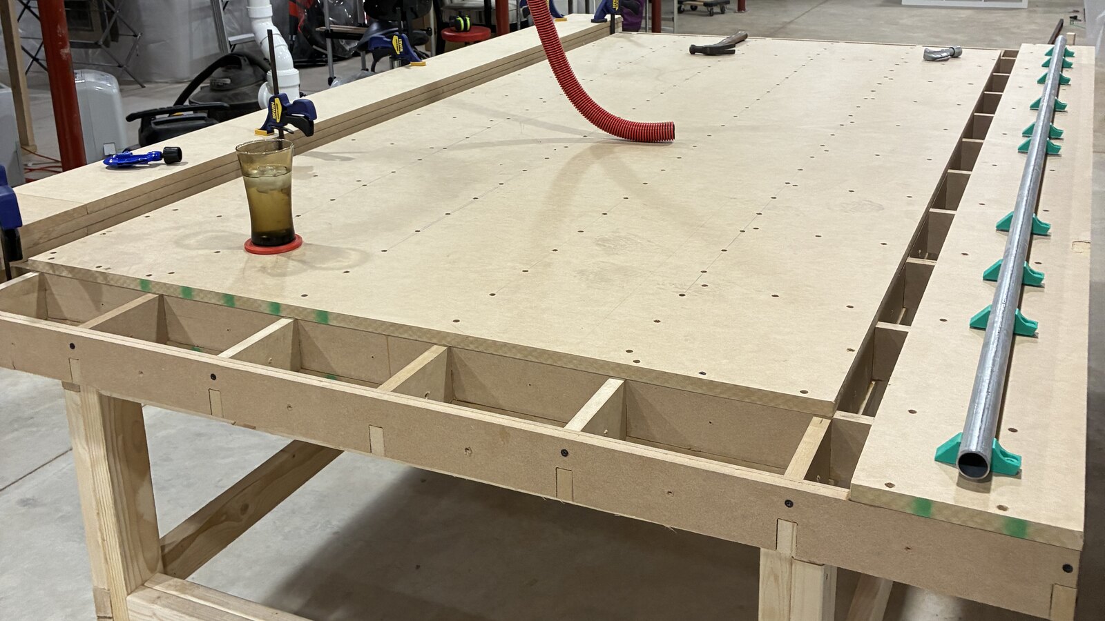 The finished torsion table in the shop, its MDF egg crate core visible along the open edge, with the CNC machine's rails being fitted down one side